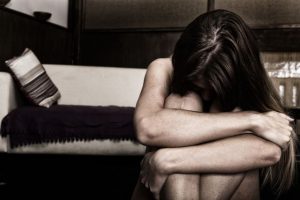 部屋でうずくまる女性